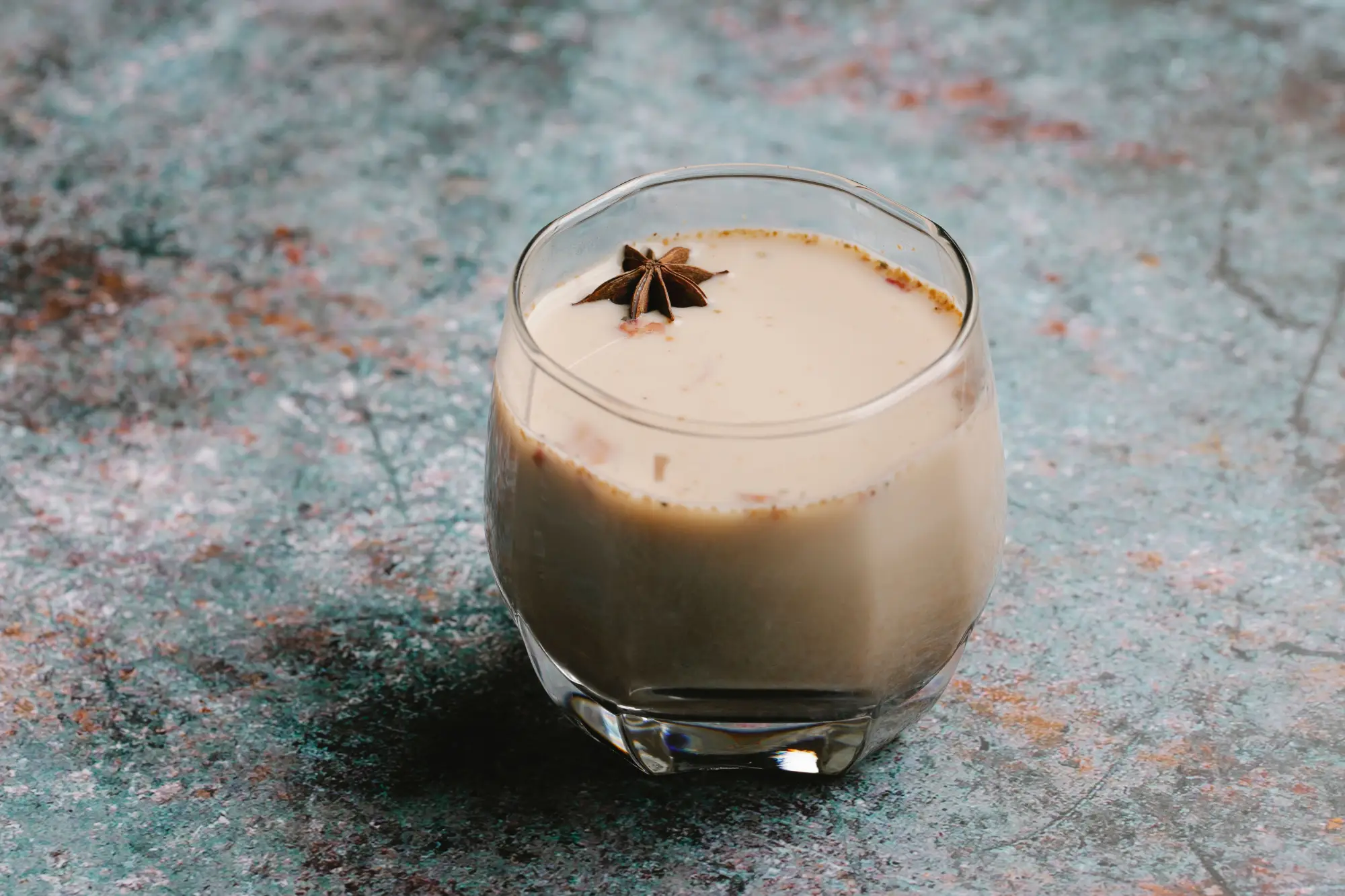 Especias del chai latte: canela, cardamomo, clavo y jengibre sobre una tabla de madera