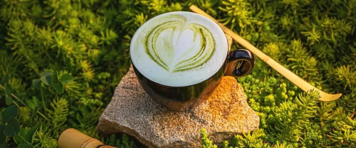 Dia internacional del te. Taza de matcha latte caliente con diseño de corazón en espuma.