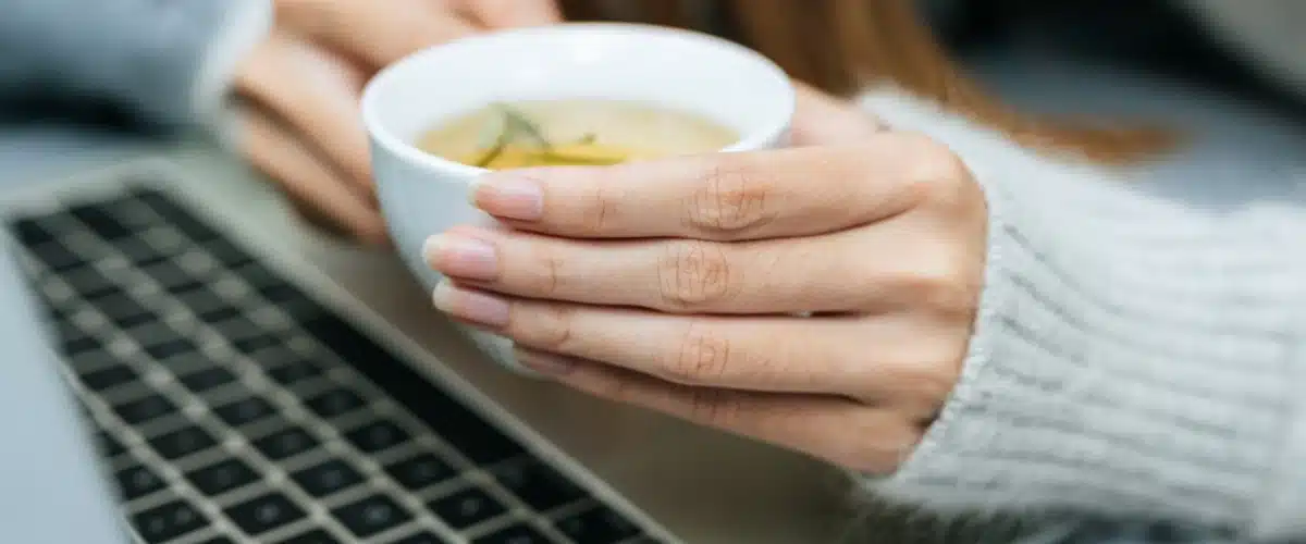 Qué tomar para la memoria y concentración: persona tomando té durante una sesión de estudio