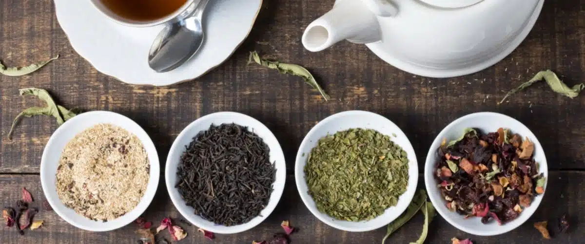 Variedades de té verde a granel junto a una tetera artesanal - comprar te online en tienda especializada Asuca Sevilla